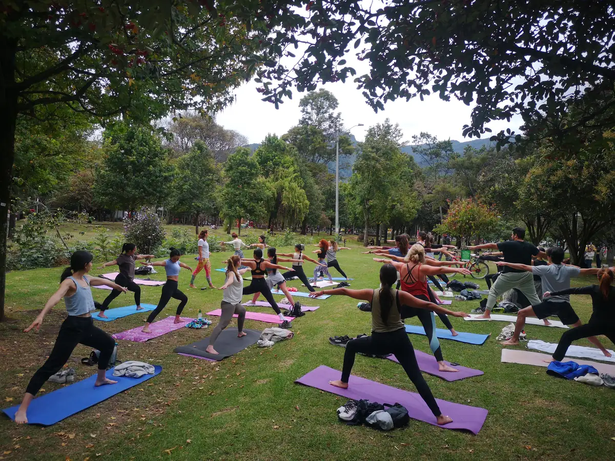 Clase de yoga al aire libre en el Parque El Virrey, con los cerros de Bogotá al fondo